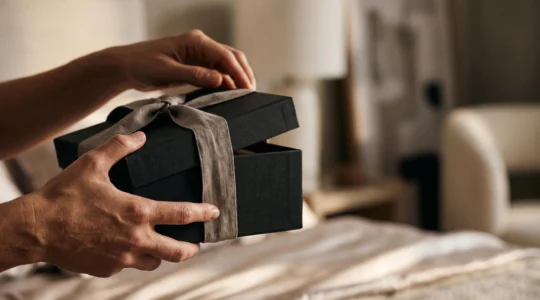 Coffret élégant entrouvert évoquant la découverte intime en couple, dans une ambiance chaleureuse et raffinée