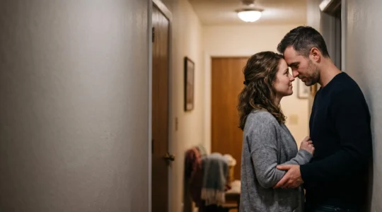 Couple partageant un moment de complicité et de tension romantique renouvelée dans une lumière chaude et intime